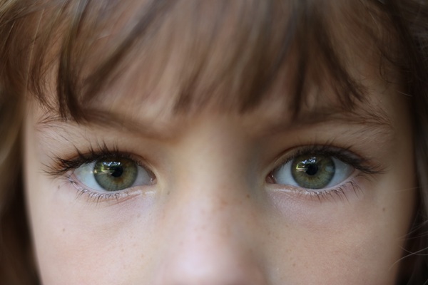 Close up of a young brown haired girl with piercing green eyes. (165604777)