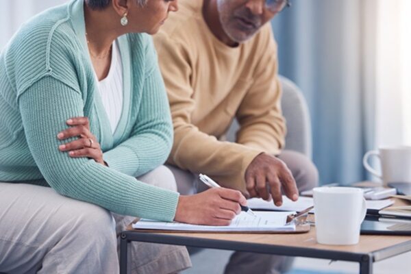 A married couple reviews New Jersey estate planning documents together while sitting at a table.